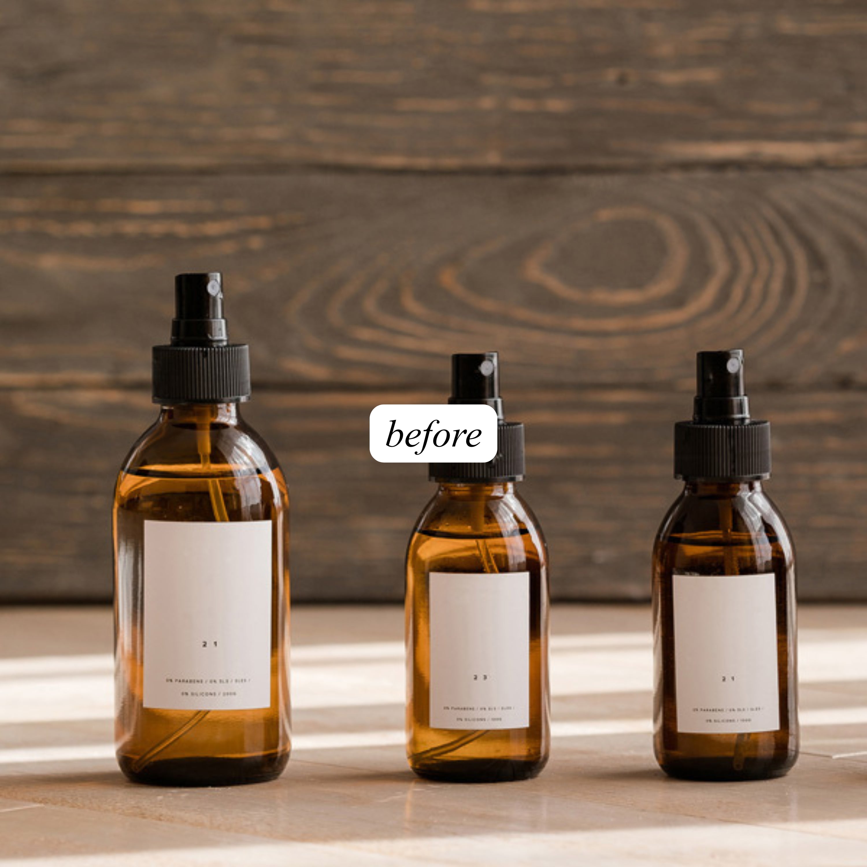 Three amber glass bottles with black sprayers on a dark planked wooden surface, with 'before' label.
