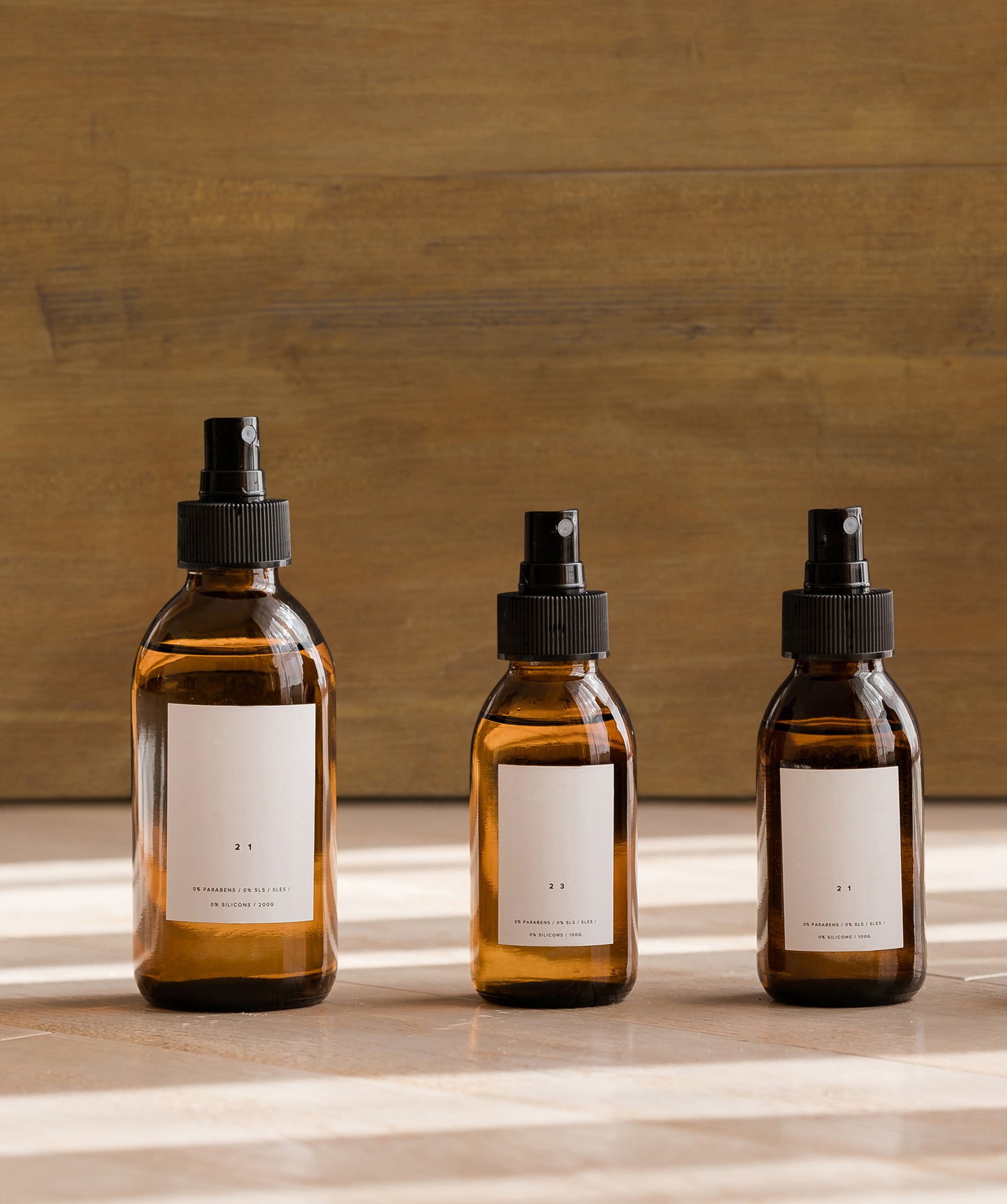 glass dropper bottles in a line in front of a wooden background