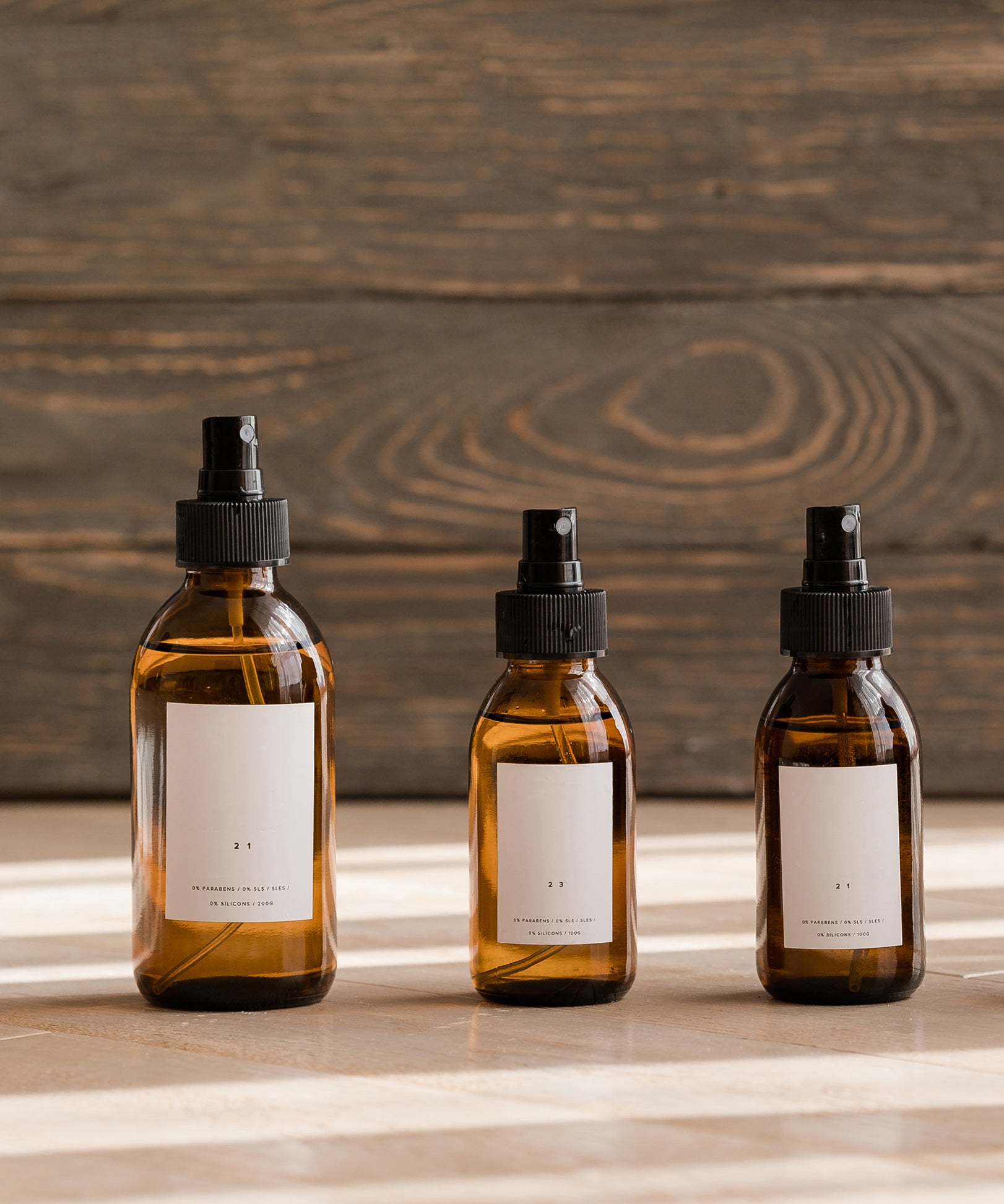 glass dropper bottles in a line in front of a planked wooden background